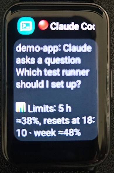 A fitness band showing the same kind of push: demo-app, Claude asks a question, which test runner should I set up, and the usage limits